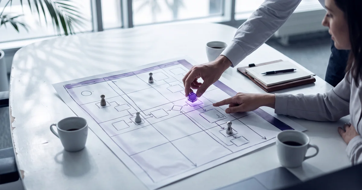Two people placing a glowing purple token representing an AI employee onto a workflow map, alongside pawns representing people